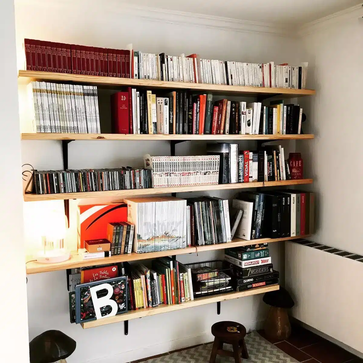 Bibliothèque sur mesure en bois clair, optimisée pour un espace de rangement fonctionnel et esthétique, exemple de menuiserie intérieure artisanale.