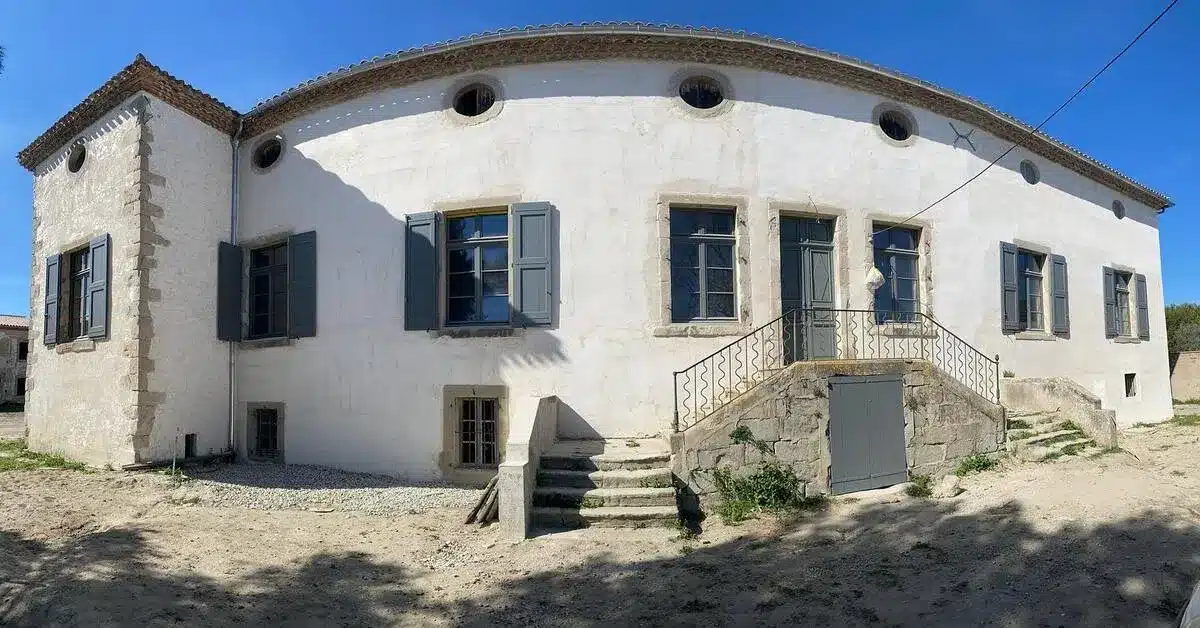 Façade de maison avec volets en bois rénovés, mettant en valeur un savoir-faire artisanal en rénovation de menuiserie extérieure.