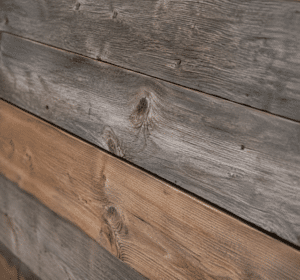Planches de bois vieilli grises et brunes montrant grain et nœuds naturels.